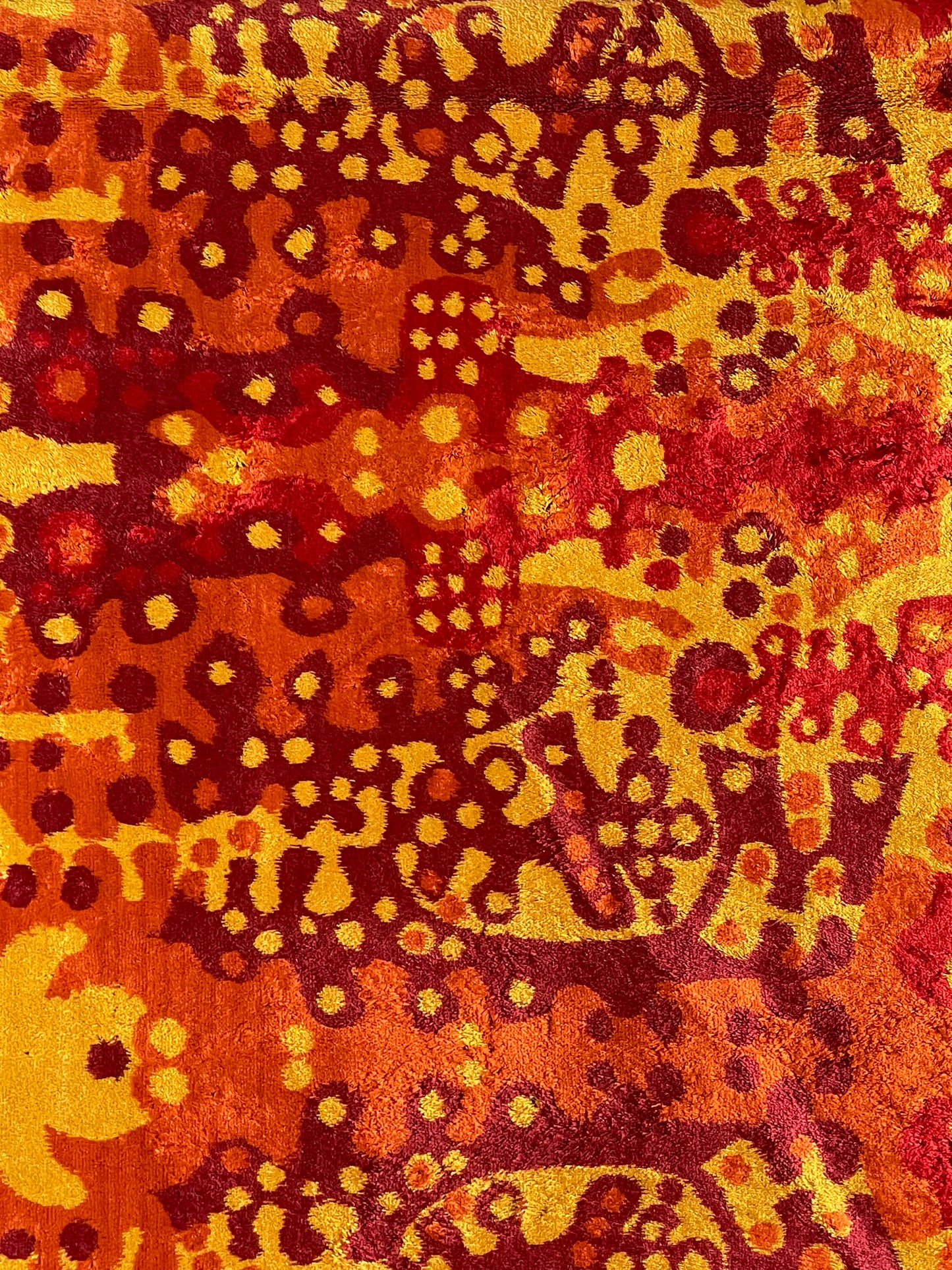 Vivid, abstract wall carpet in red/orange/yellow with organic shapes