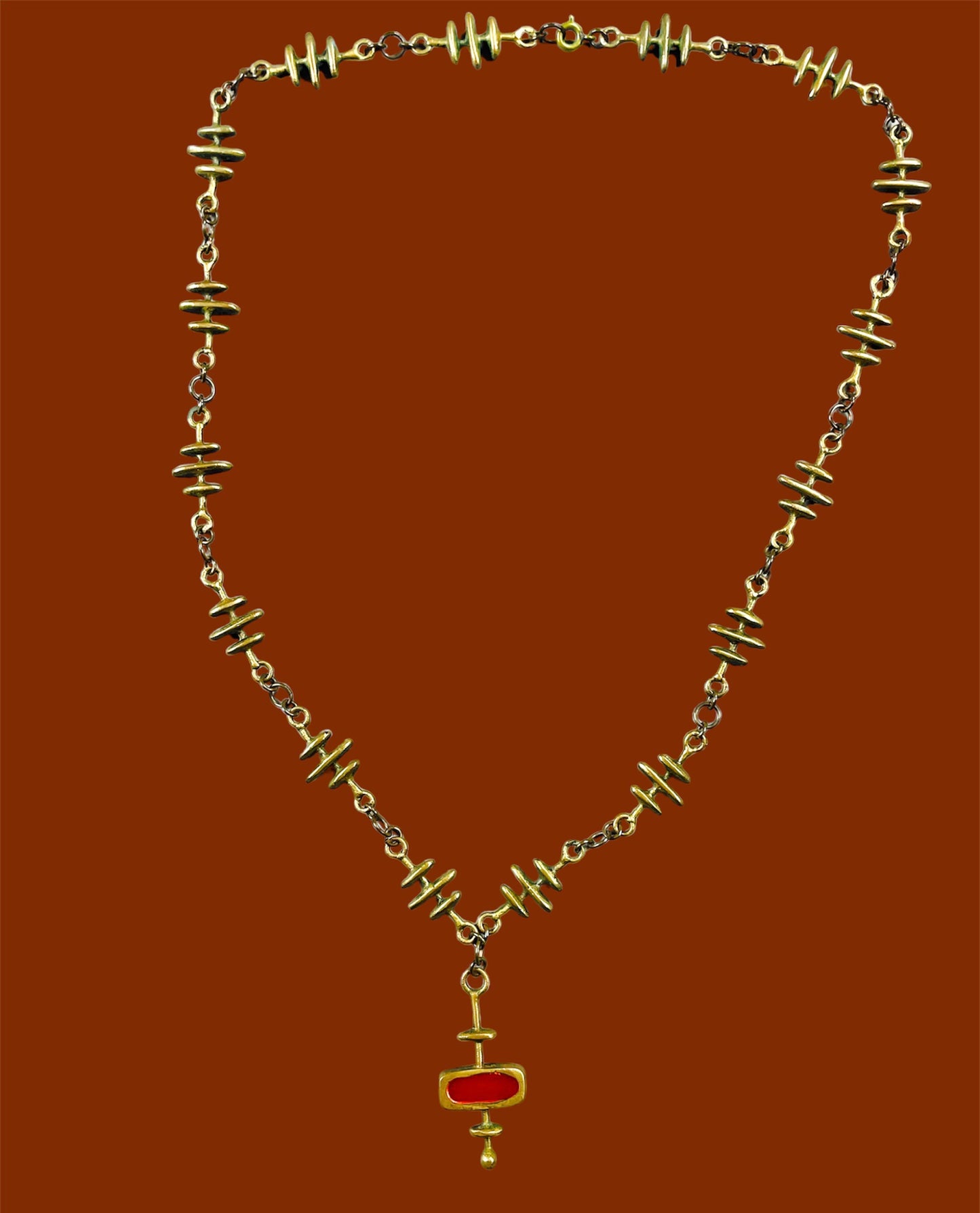 Yellow copper decorated chain and abstract geometric pendant with red enamel